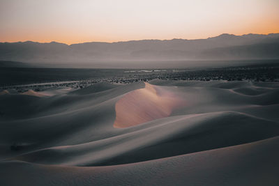 Scenic view of desert against sky during sunset