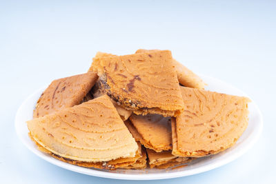 Close-up of bread in plate against white background