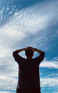 Rear view of man standing against sky