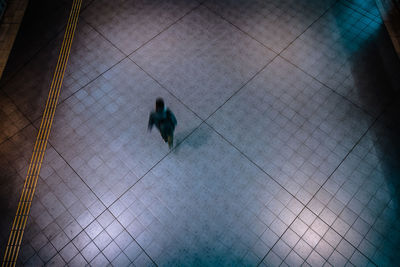 High angle view of people walking on tiled floor