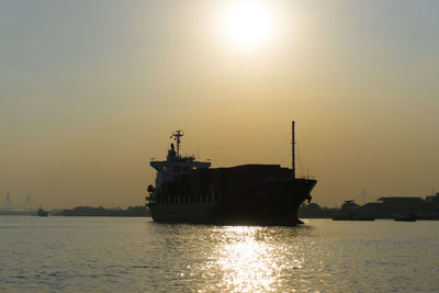 Ship sailing on sea against sky during sunset