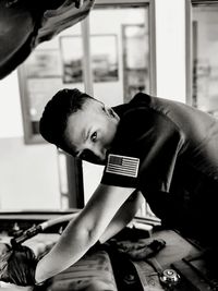 Portrait of mechanic repairing car at garage