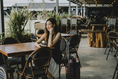 Beautiful woman looking away while sitting at cafe