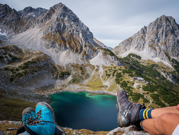 Low section of person in mountains against sky