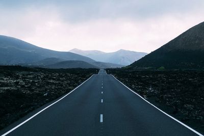Empty road with mountains in background