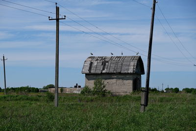 Electricity pylon on field against sky