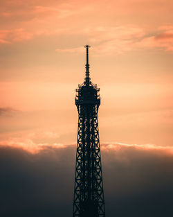 Low angle view of communications tower against cloudy sky