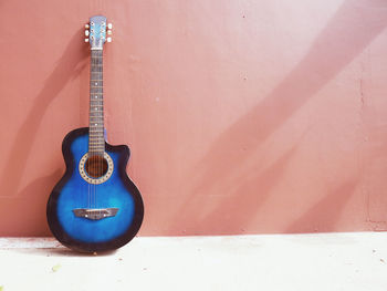 Close-up of guitar against wall