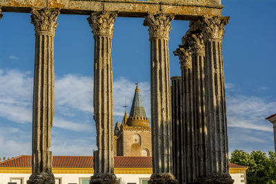 Low angle view of architectural columns against blue sky