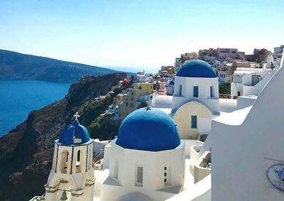 Buildings in city against clear blue sky