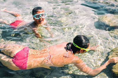 High angle view of mother and son swimming in sea