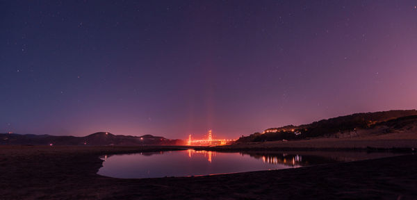 Scenic view of lake against sky at night