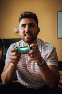 Smiling man playing video game at home