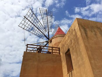 Low angle view of mill against sky