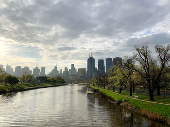River amidst buildings in city against sky