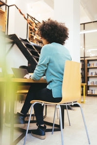 Businesswoman working on laptop at desk in creative office