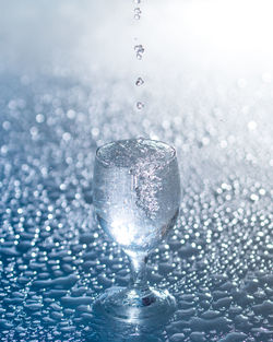Close-up of water drops on glass against blue background