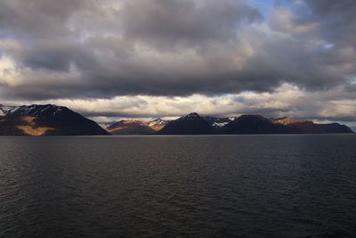 Scenic view of sea and mountains against sky