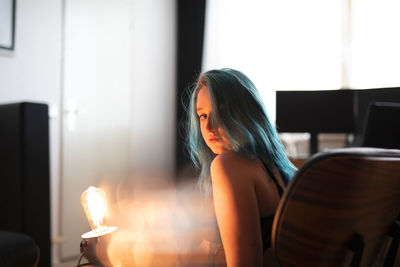 Woman looking away while sitting on table