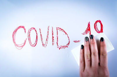 Midsection of woman holding hands against white background