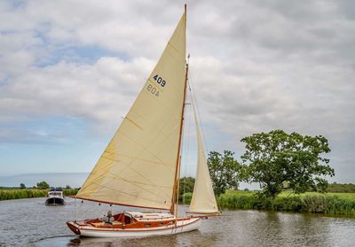 Sailboat sailing in sea against sky