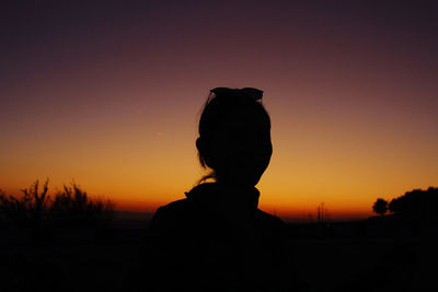 Silhouette man standing against orange sky