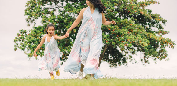 Women standing on field against trees