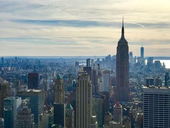 View of cityscape against cloudy sky