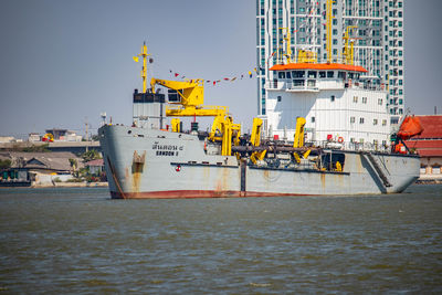 Ship moored at harbor against clear sky