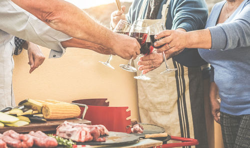 Midsection of people toasting wineglasses