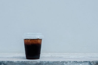 Close-up of coffee on table against wall