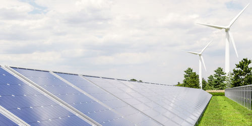 Solar panels and wind turbine on the sky background.3d rendering