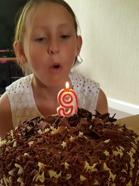 Close-up of baby girl with cake on table