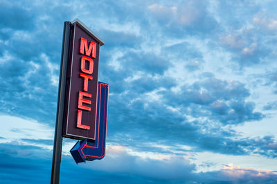 Low angle view of information sign against sky