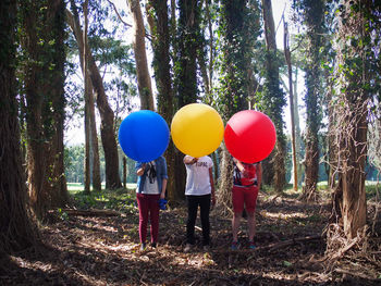 Rear view of woman standing by tree