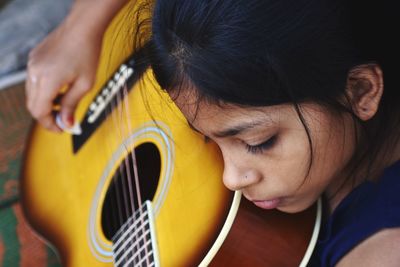 Close-up of girl playing guitar