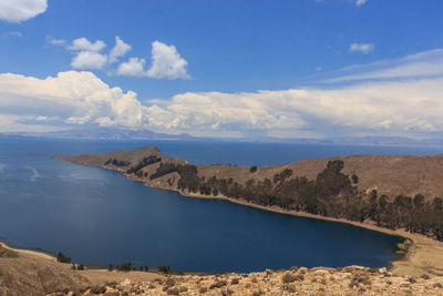 Scenic view of sea and mountains against sky