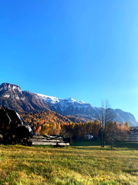 Scenic view of field and mountains against blue sky