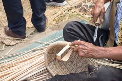 Midsection of man making basket outdoors