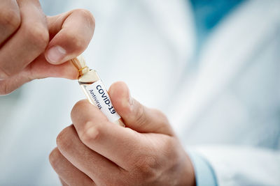 Midsection of doctor holding dentures