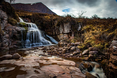 Scenic view of waterfall against sky