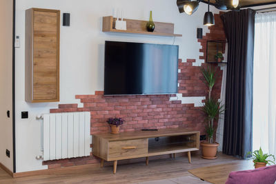 Potted plant on table by window at home