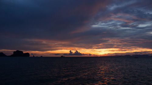 Scenic view of sea against cloudy sky during sunset