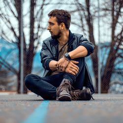 Young man sitting in forest