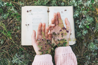 High angle view of person hand on book