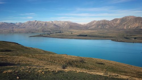 A stunning view of milky-turquoise blue lake tekapo from mount john in new zealand during autumn.