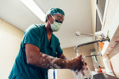 Low angle view of doctor washing hands