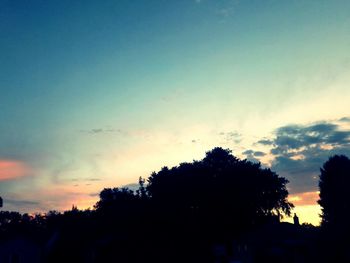 Low angle view of silhouette trees against sky at sunset