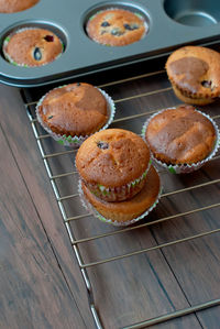 High angle view of cupcakes on cooling rack over table