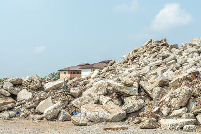 Low angle view of rocks and buildings against sky
